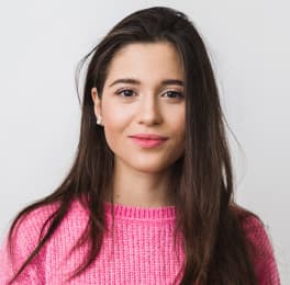 Young dark-haired beautiful girl in pink sweater