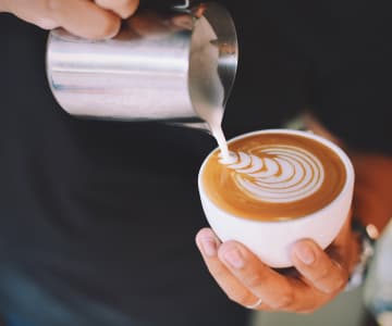 Barista makes a patterned cappuccino